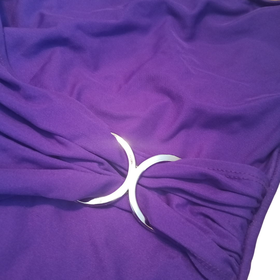 Close-up of a purple bathing suit with a silver accent on a white background
